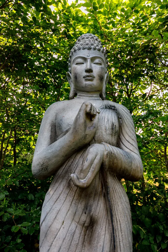 Stone Buddha statue in the gardens of the retreat