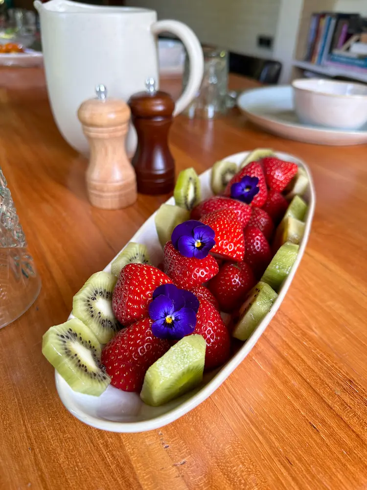 Bowl of strawberries and kiwi with edible flowers