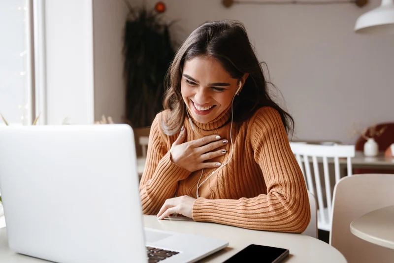 Smiling woman attending a live session from her laptop
